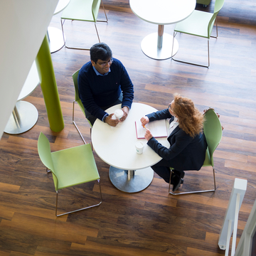Two people having a sit-down interview at a cafe table