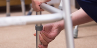 Image of hands adjusting the feet of a walking frame