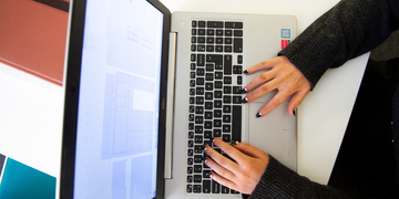 Student typing at laptop